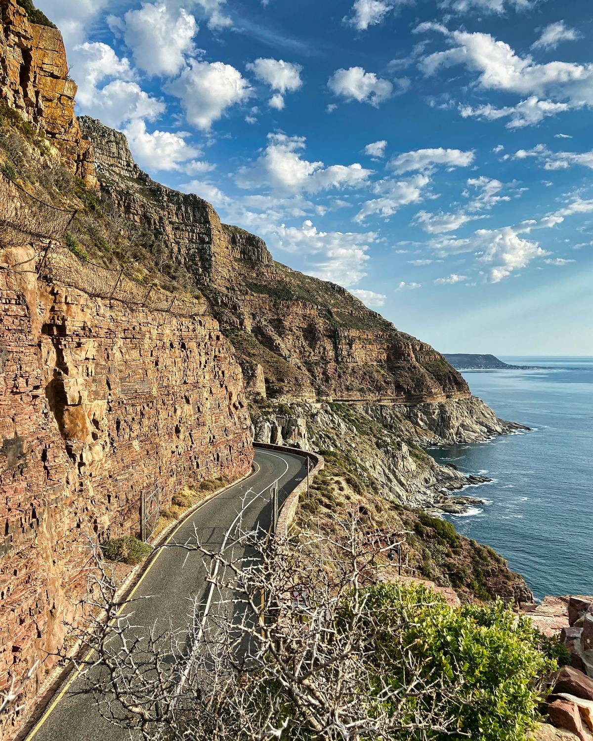 A winding coastal road between the cliffs of Chapman’s Peak and the Atlantic Ocean.